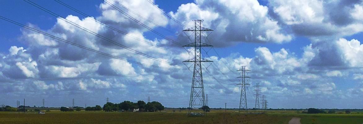 Power lines under a cloudy blue sky.