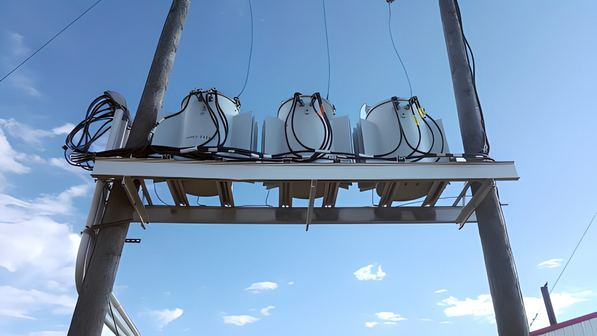 Electrical equipment mounted on utility poles outdoors.